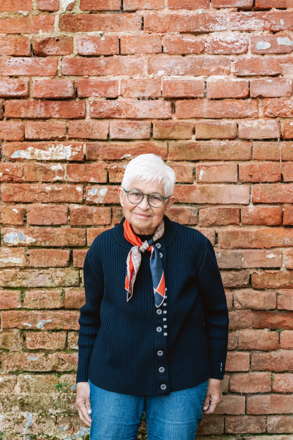 The customer Stefania in her green Kaleos glasses standing by the wall