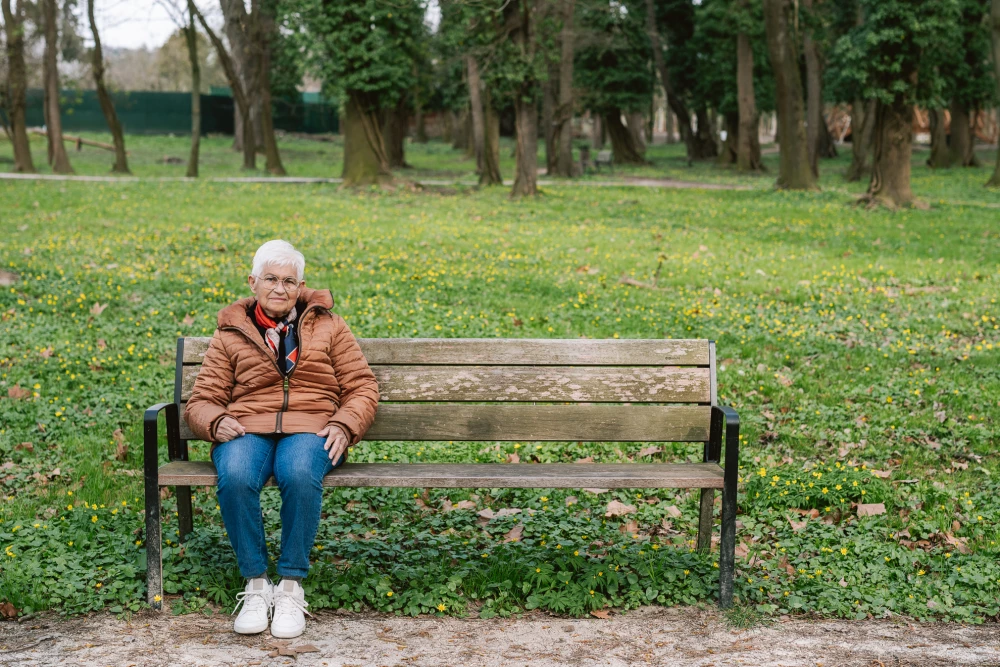 Stefania in her Komono frames sitting on a bench